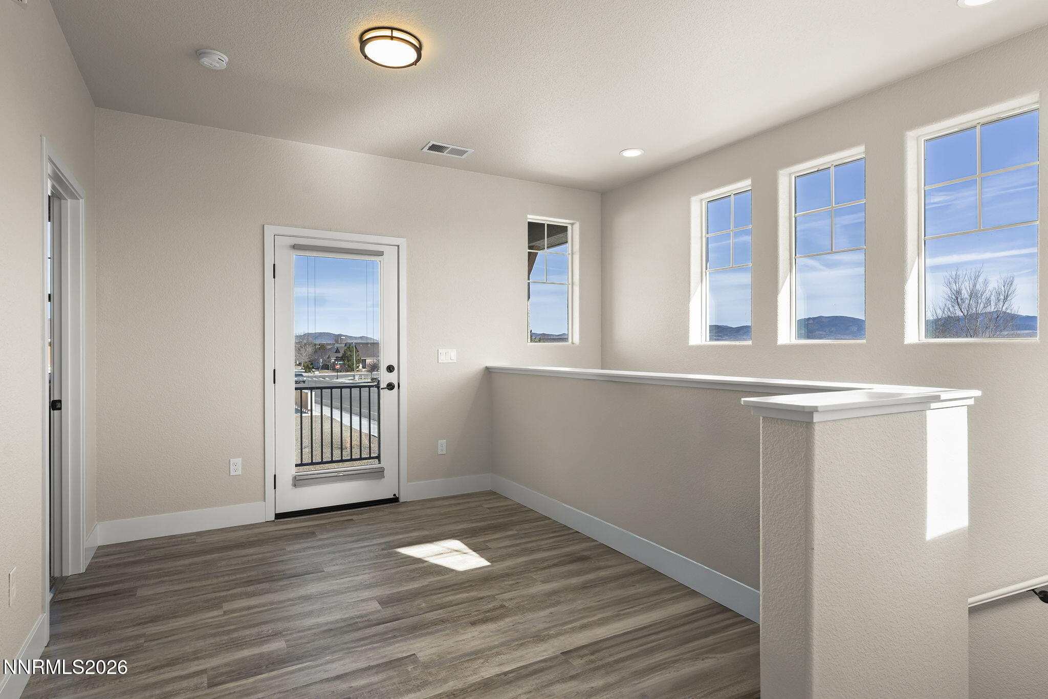 300 Cattail Circle Gardnerville, NV 89410 - Photo 8 of 39 an empty room with wooden floor and windows