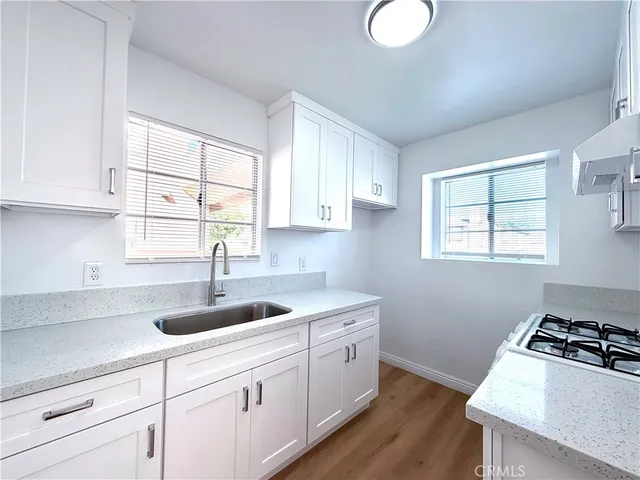 a kitchen with white cabinets and a window