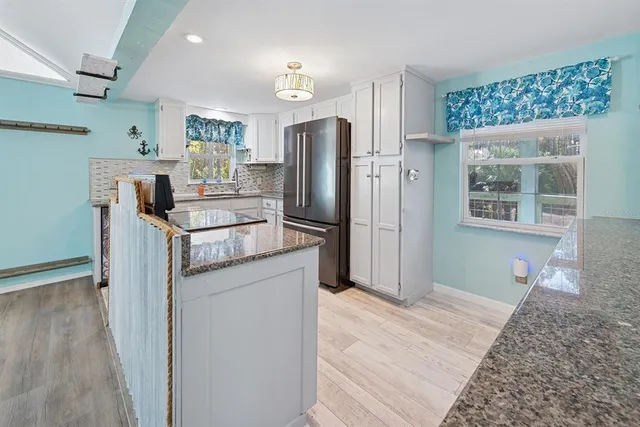 a kitchen with granite countertop a sink cabinets and stainless steel appliances