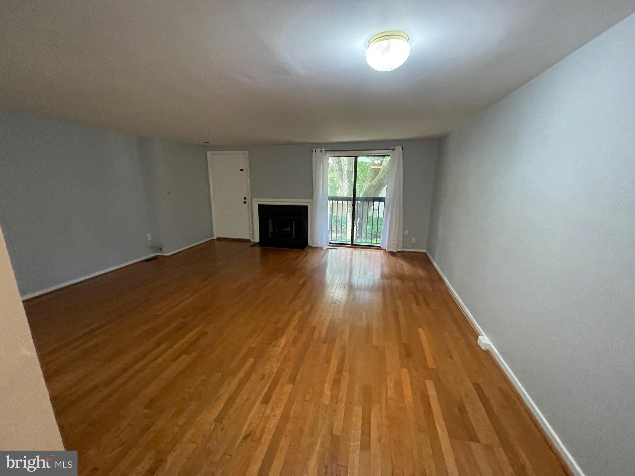 9815 Hellingly Place, Unit 75 Montgomery Village, MD 20886 - Photo 1 of 14 a view of an empty room with wooden floor and a window