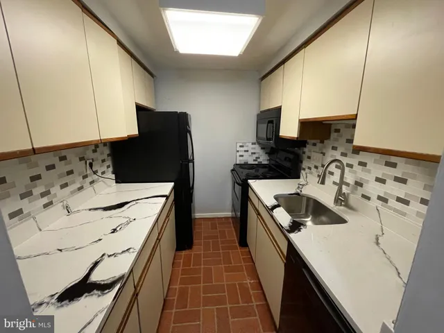a kitchen with stainless steel appliances a stove a sink and a refrigerator