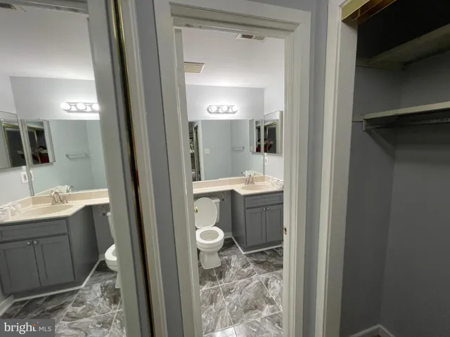 a bathroom with a sink and mirror with toilet