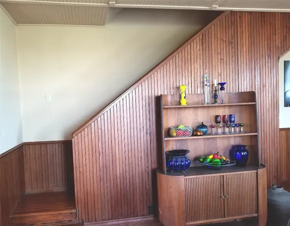 a bedroom with a bed and a dresser next to a window
