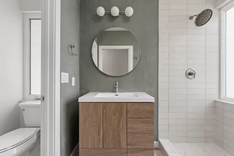 a bathroom with a sink a toilet and shower
