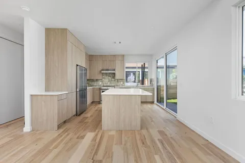 a kitchen with a refrigerator and white cabinets