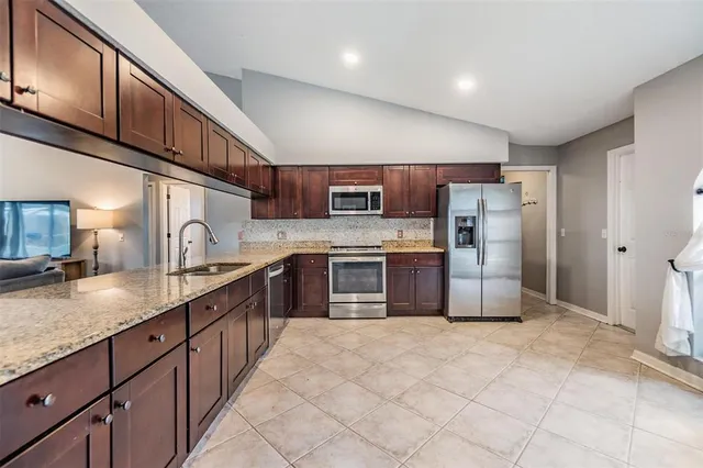 a kitchen with stainless steel appliances granite countertop a refrigerator a stove a sink and a granite counter tops