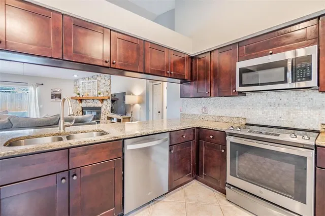 a kitchen with cabinets appliances a sink and a counter top space