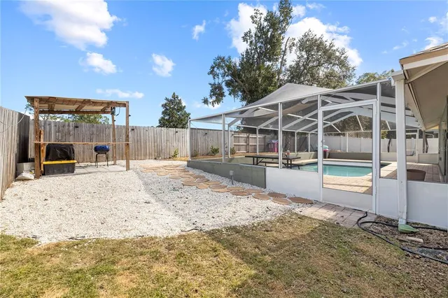a view of a house with a yard and wooden fence