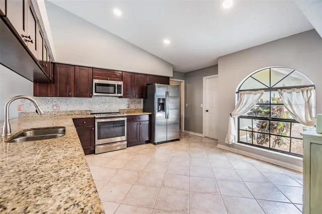 a kitchen with stainless steel appliances a microwave a stove and a sink