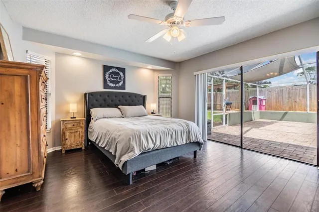 a spacious bedroom with a bed and wooden floor
