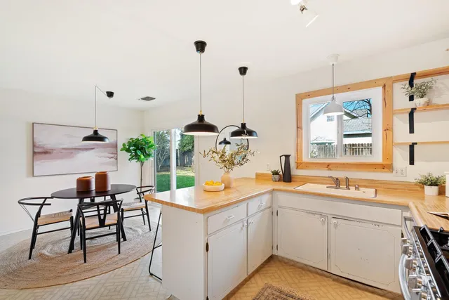 a kitchen with a sink and chairs