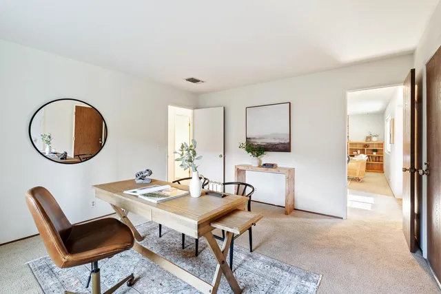 a view of a dining room with furniture and a mirror