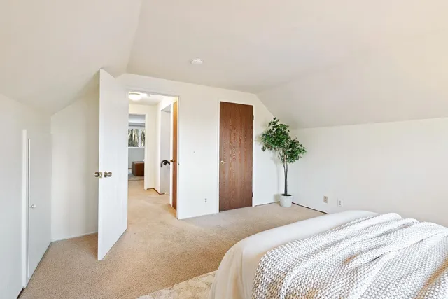 a bedroom with a bed and potted plant