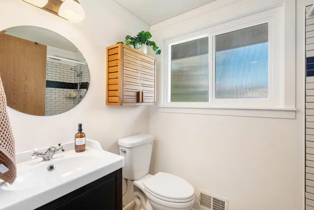 a bathroom with a sink a toilet and a mirror