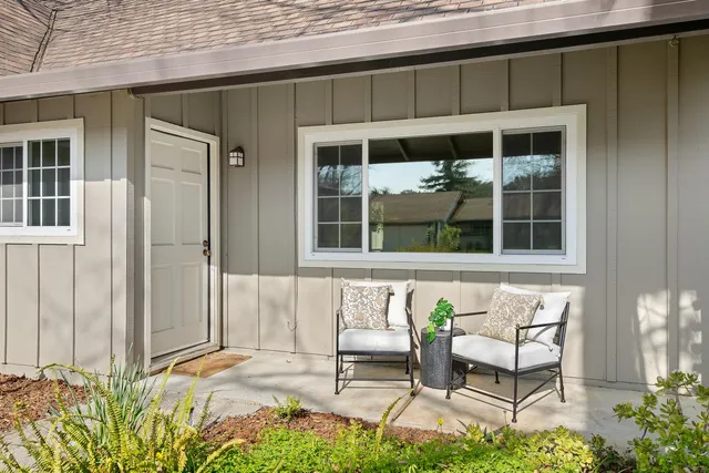 a balcony with table and chairs and potted plants