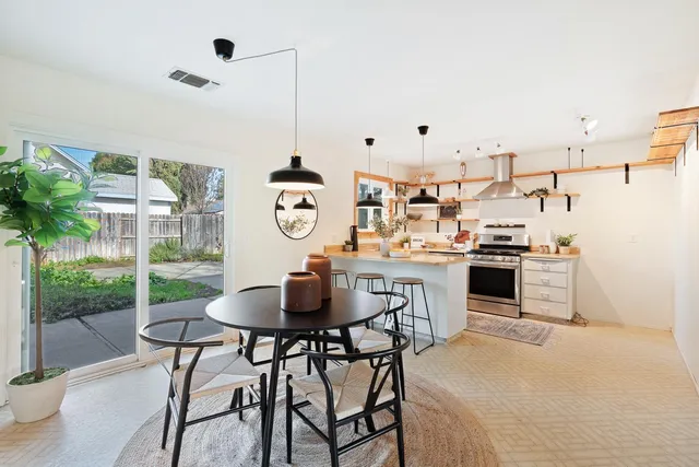 a kitchen with stainless steel appliances kitchen island granite countertop a table and chairs in it