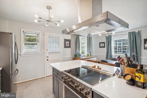a kitchen that has a lot of cabinets stainless steel appliances and a large window