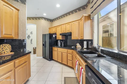 a kitchen with stainless steel appliances granite countertop a stove a sink and a refrigerator