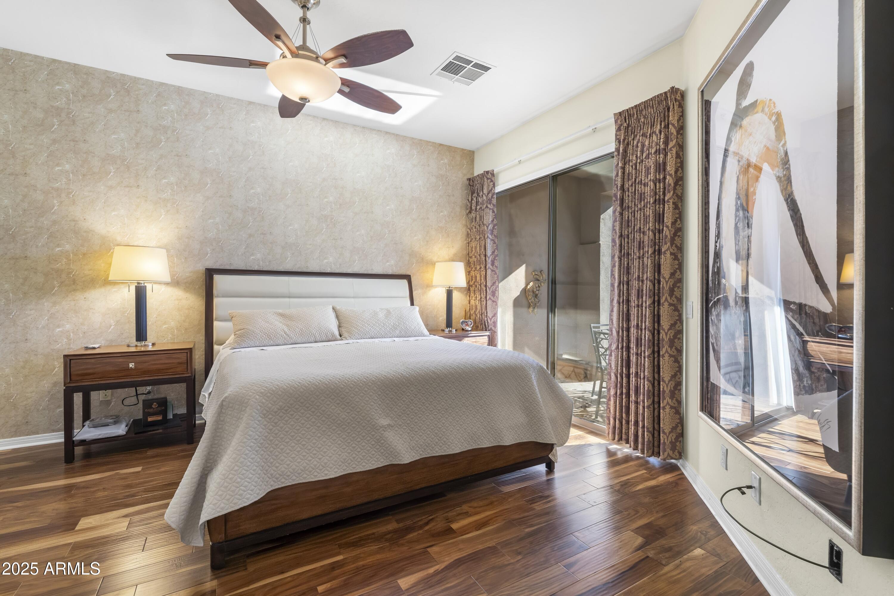 7267 East Vaquero Drive Scottsdale, AZ 85253 - Photo 17 of 37 a bedroom with a large bed and a chandelier