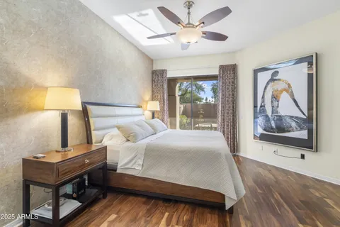 a bedroom with a bed wall painting and a window