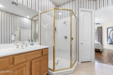a bathroom with a double vanity sink mirror and shower