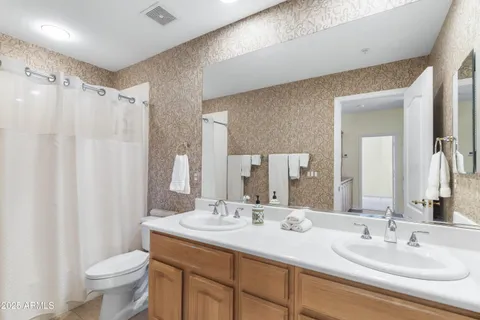 a bathroom with a double vanity sink toilet and a mirror
