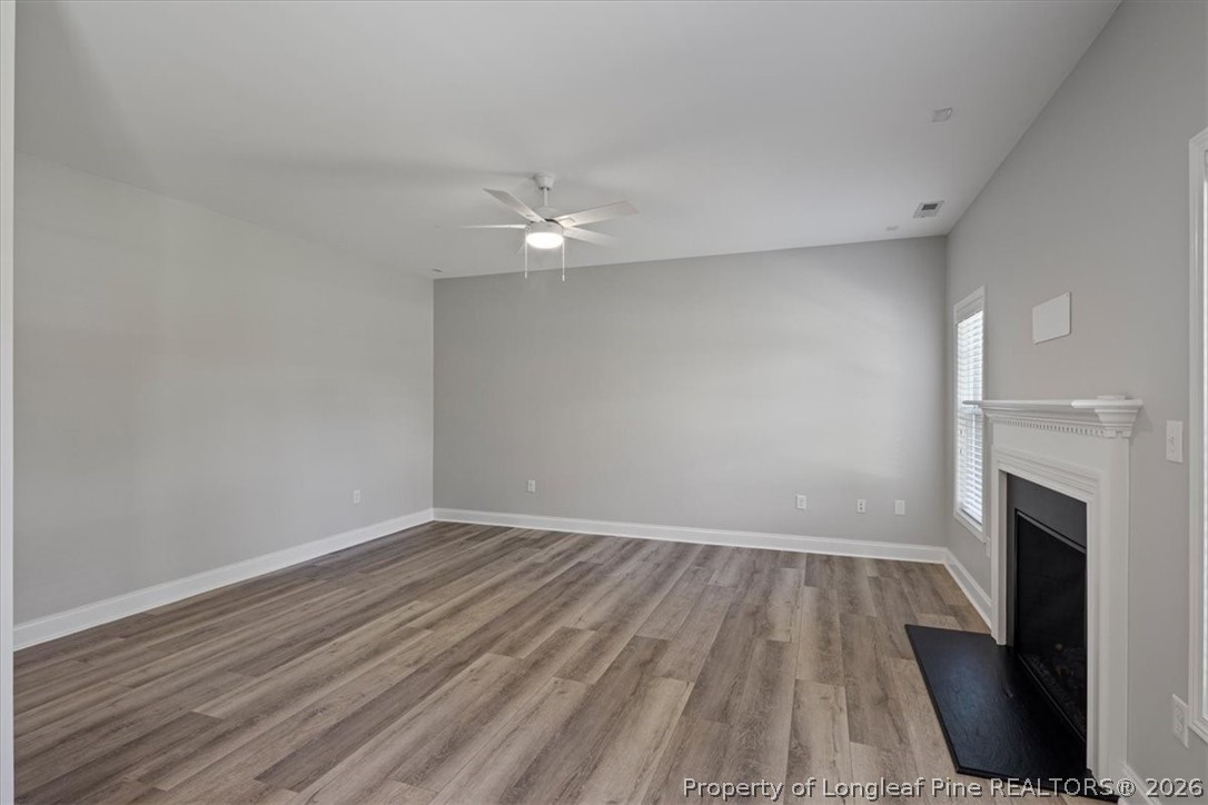 134 Huzzas Circle Cameron, NC 28326 - Photo 10 of 31 wooden floor in an empty room with a fireplace