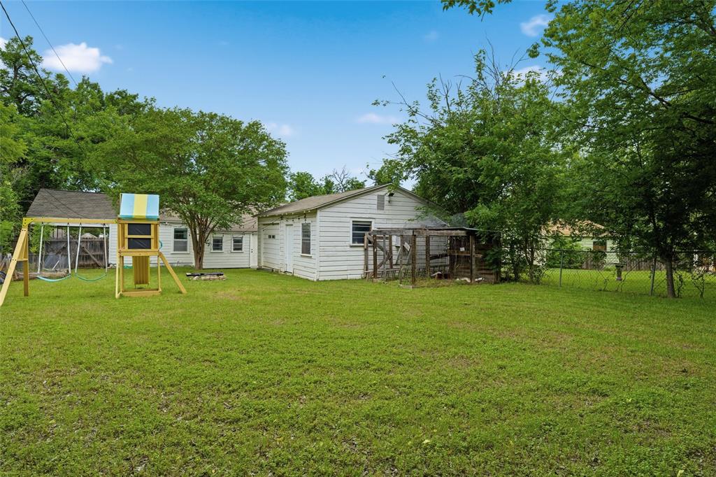 3012 Mitchell Avenue Waco, TX 76708 - Photo 14 of 18 Expansive backyard with a manicured lawn, established perimeter trees, and a detached structure featuring white siding and a wood-slat enclosure