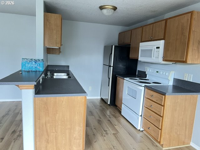 659 Northeast 162nd Avenue, Unit 302 Portland, OR 97230 - Photo 8 of 17 a kitchen with a refrigerator a stove top oven a sink and dishwasher