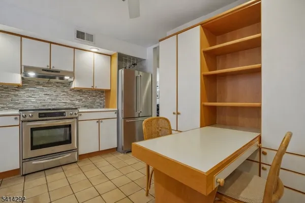 a kitchen with kitchen island granite countertop cabinets and stainless steel appliances