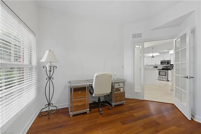 a view of a workspace with furniture and a window
