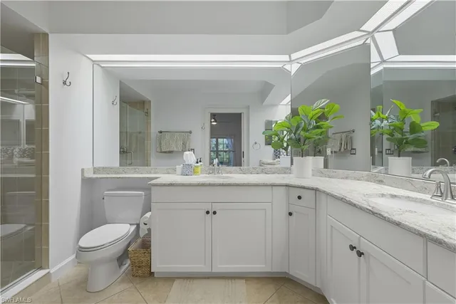 a bathroom with a granite countertop sink a toilet and a mirror
