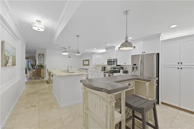 a kitchen with kitchen island a stove a table and chairs in it