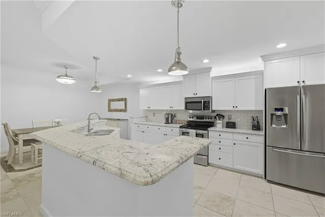 a kitchen with stainless steel appliances granite countertop a sink refrigerator a stove a microwave and island