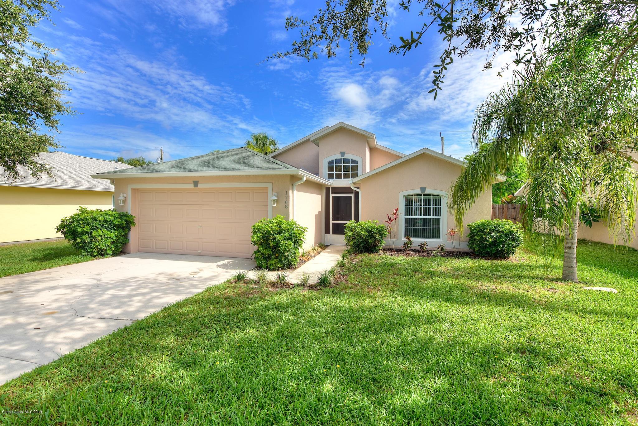 1768 Palm Ridge Road Melbourne, FL 32935 - Photo 2 of 20 a front view of a house with a yard