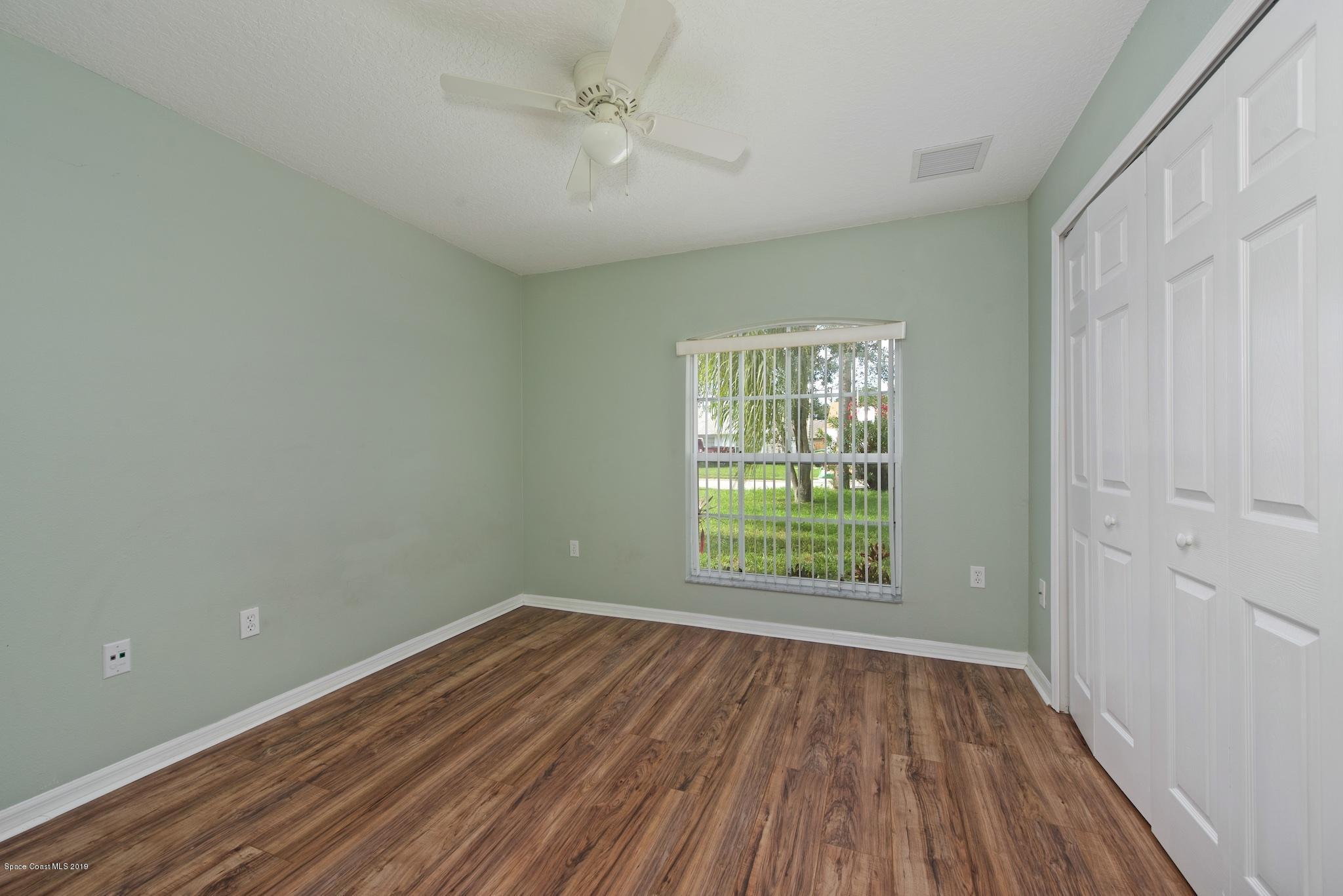1768 Palm Ridge Road Melbourne, FL 32935 - Photo 13 of 20 wooden floor in an empty room with a window