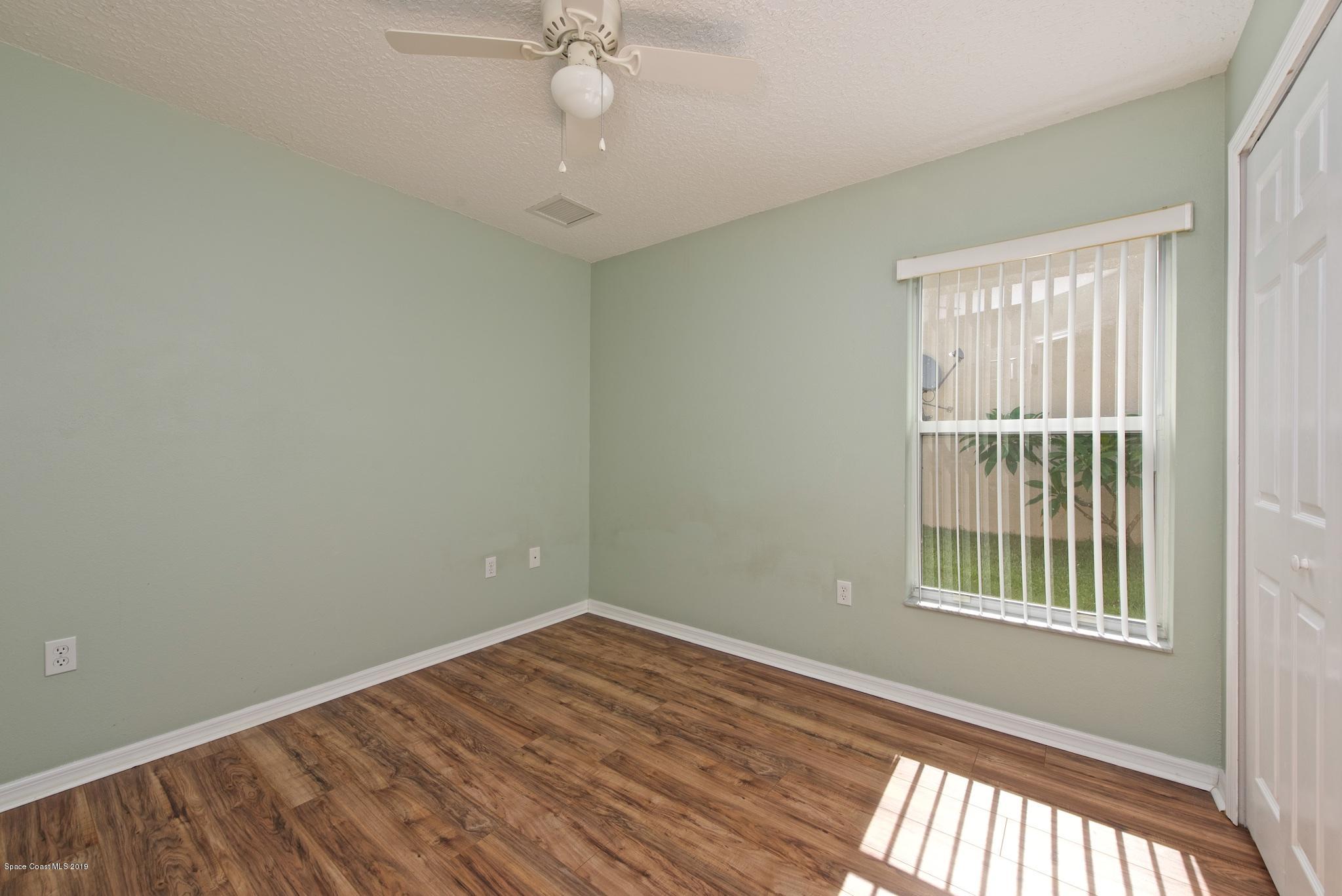 1768 Palm Ridge Road Melbourne, FL 32935 - Photo 14 of 20 a view of an empty room with wooden floor and a window