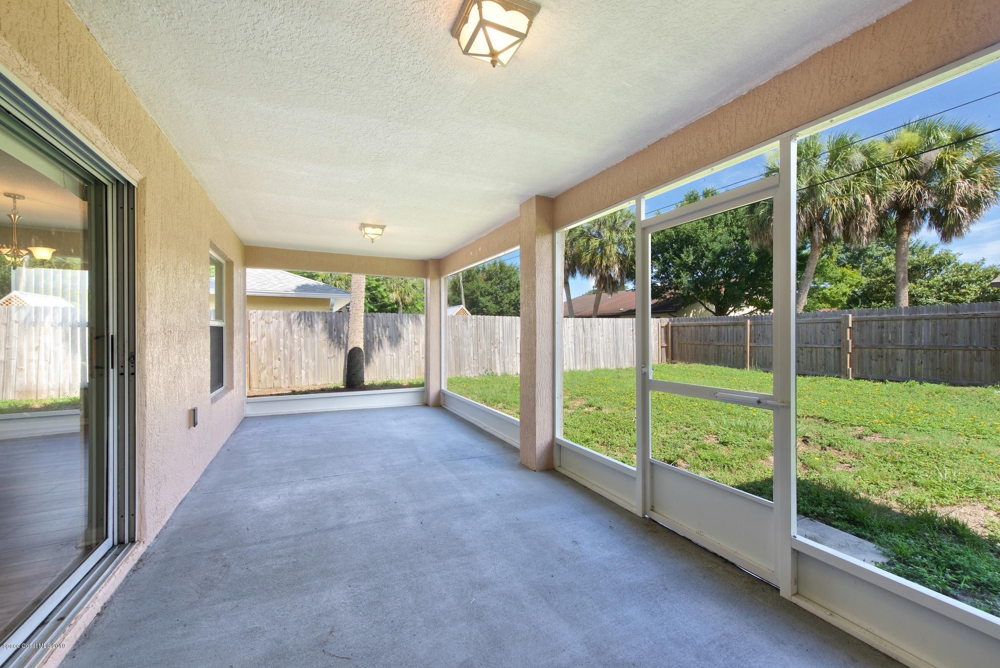 1768 Palm Ridge Road Melbourne, FL 32935 - Photo 17 of 20 a view of a big room with floor to ceiling windows and yard