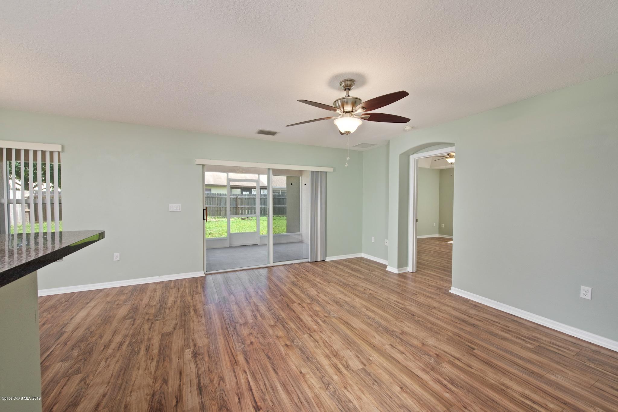 1768 Palm Ridge Road Melbourne, FL 32935 - Photo 5 of 20 a view of an empty room with a window and wooden floor