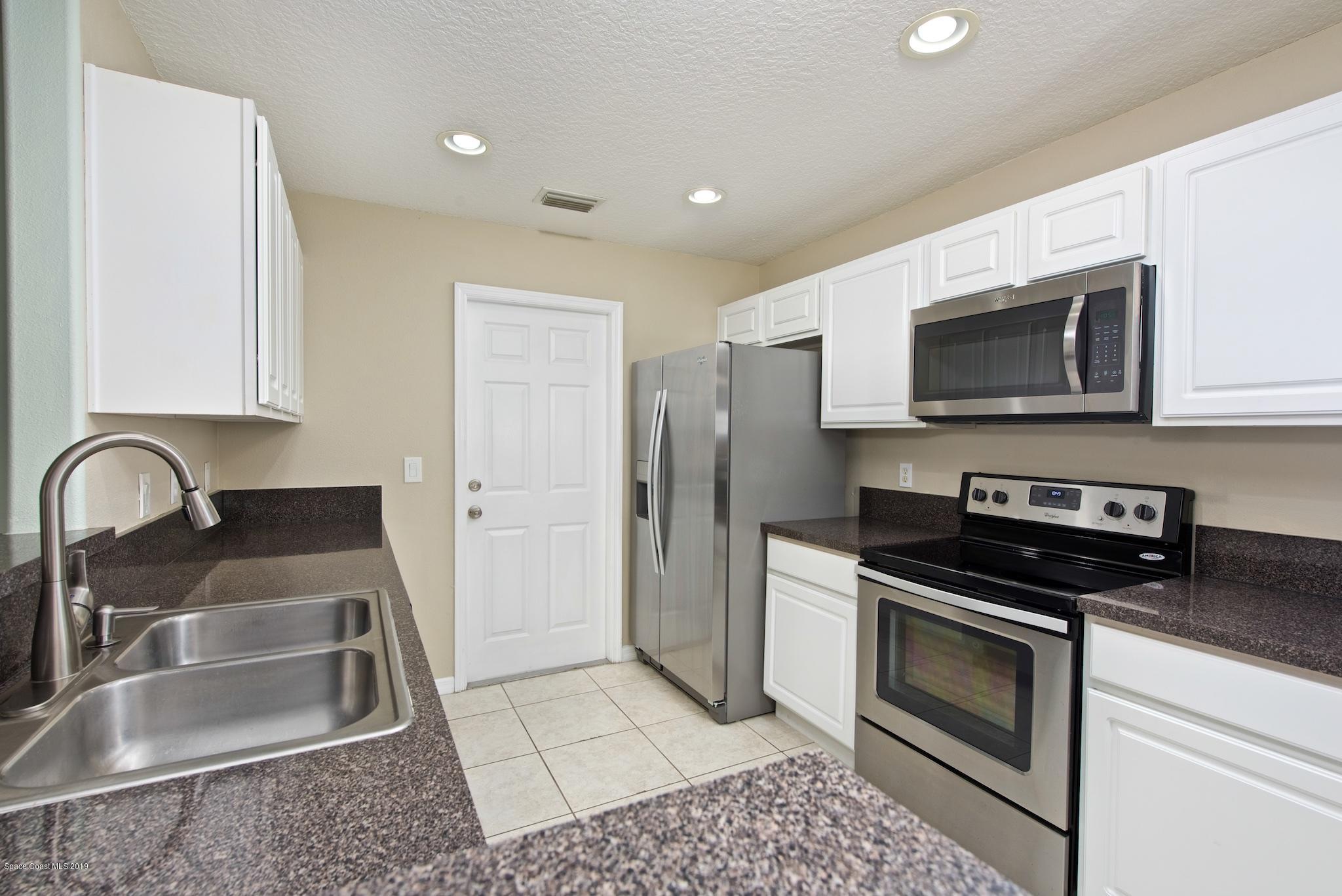 1768 Palm Ridge Road Melbourne, FL 32935 - Photo 7 of 20 a kitchen with a sink and steel appliances