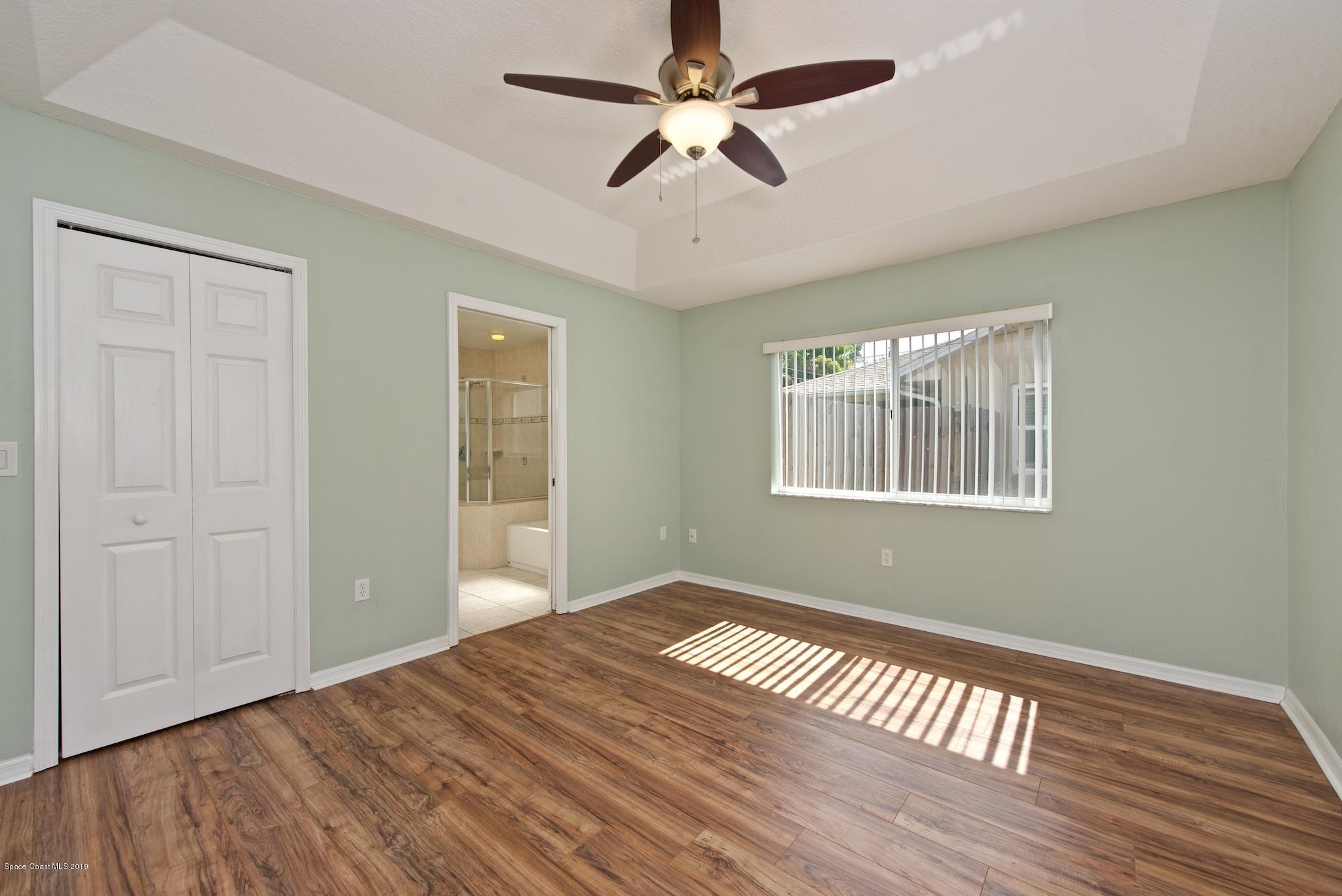 1768 Palm Ridge Road Melbourne, FL 32935 - Photo 10 of 20 a view of empty room with wooden floor and fan