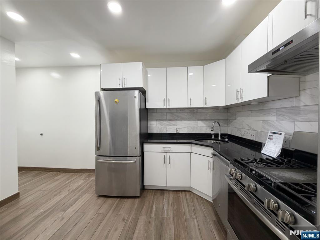26 River Edge Road River Edge, NJ 07661 - Photo 2 of 10 a kitchen with granite countertop a refrigerator and a stove top oven