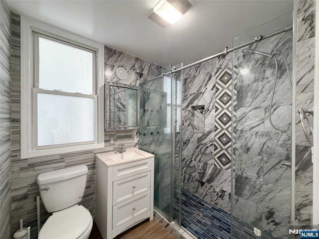 26 River Edge Road River Edge, NJ 07661 - Photo 8 of 10 a bathroom with a granite countertop sink toilet a mirror and shower
