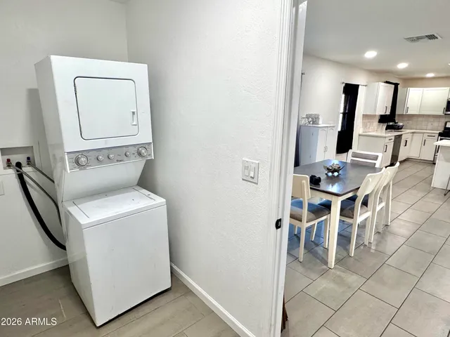 a living room with furniture a flat screen tv and kitchen view