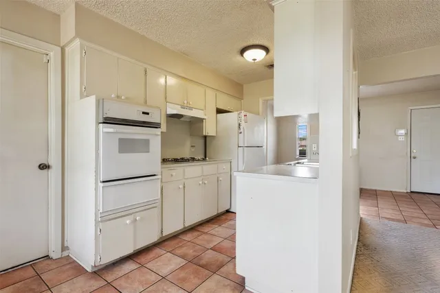 a kitchen with white cabinets and white appliances