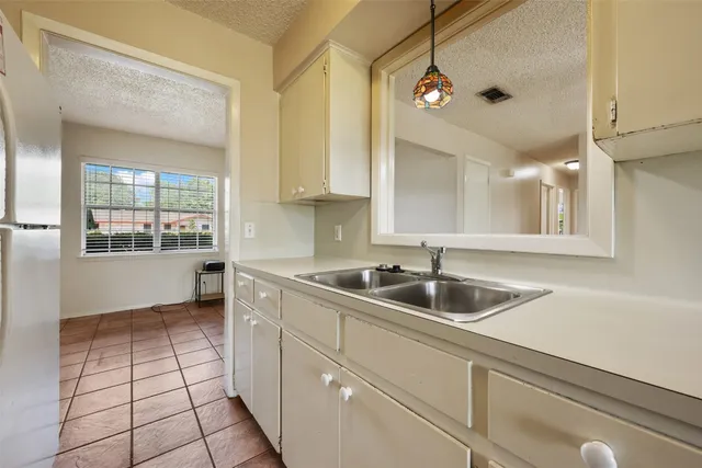 a kitchen with a sink a counter space and cabinets