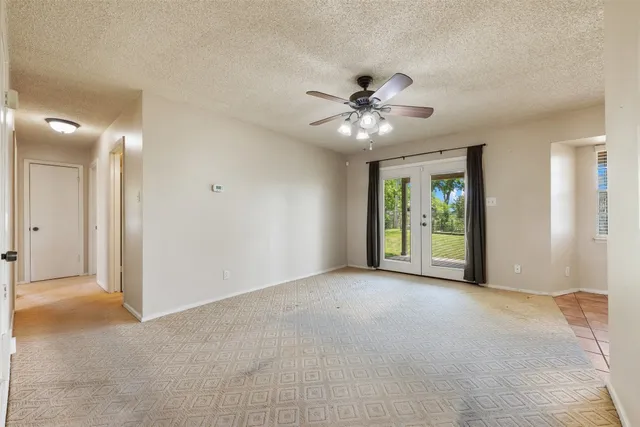 a view of a big room with chandelier fan and windows