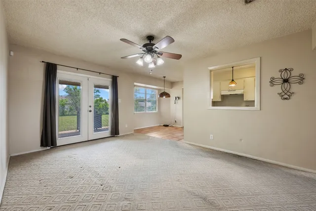 a view of a big room with windows and chandelier fan