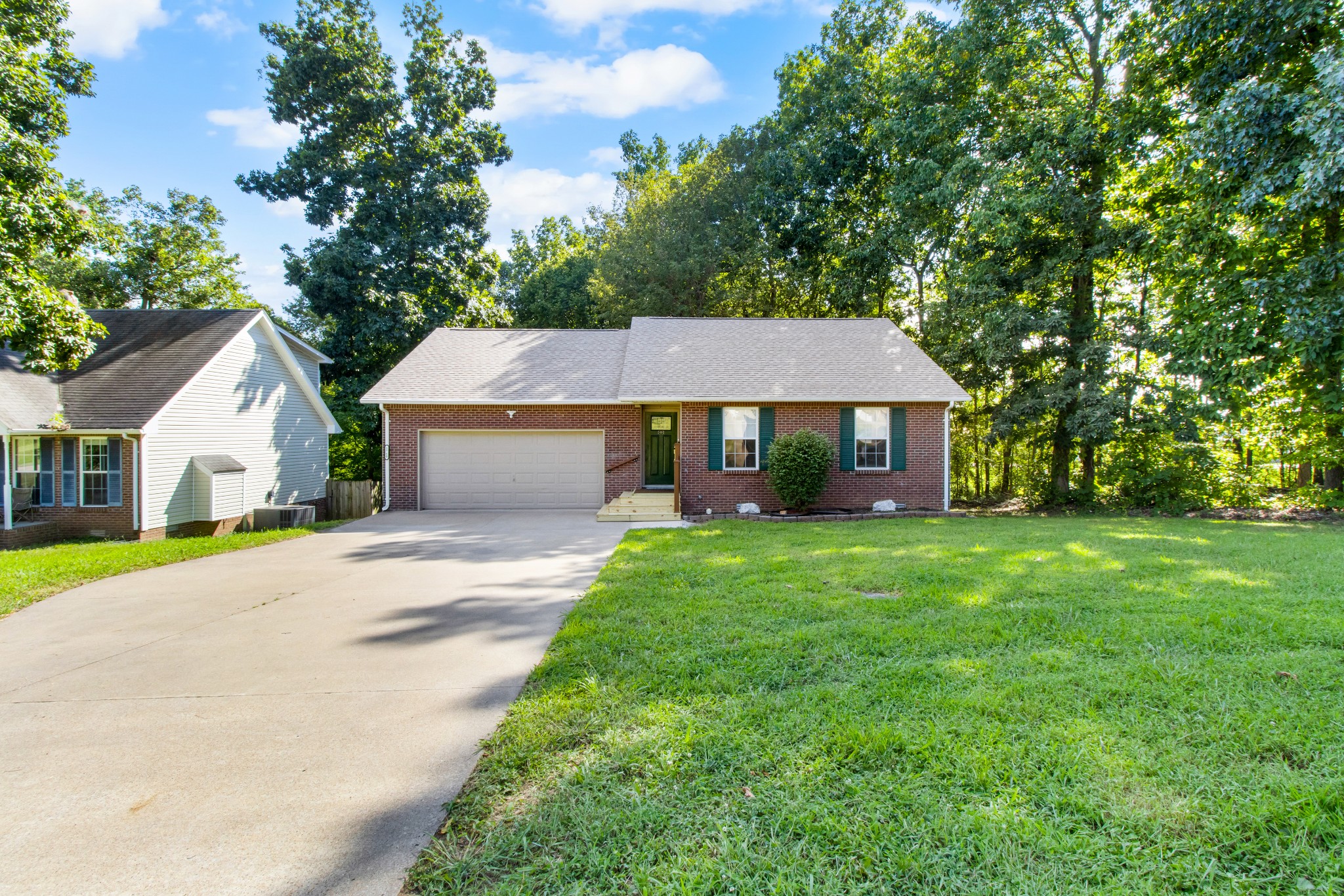 a front view of a house with a yard and trees