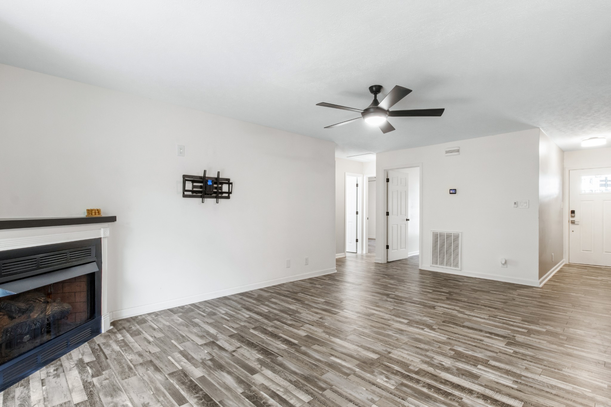 1760 Hazelwood Road Clarksville, TN 37040 - Photo 11 of 34 a view of an empty room with wooden floor a fireplace and a window